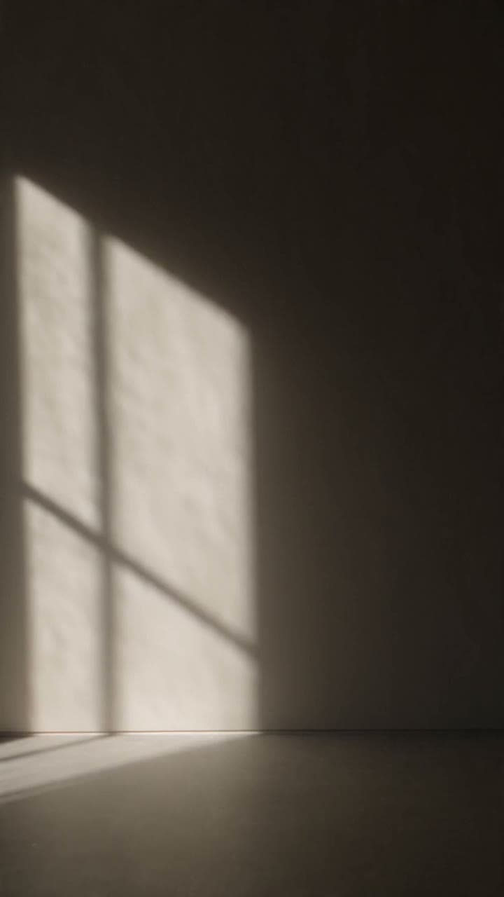 A brown leather lounge chair beside a floor lamp in a sunlit room